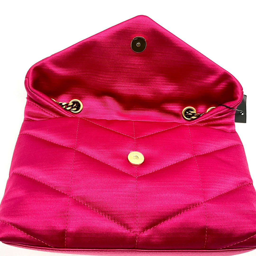 Open pink quilted pouch with gold button and chain details.