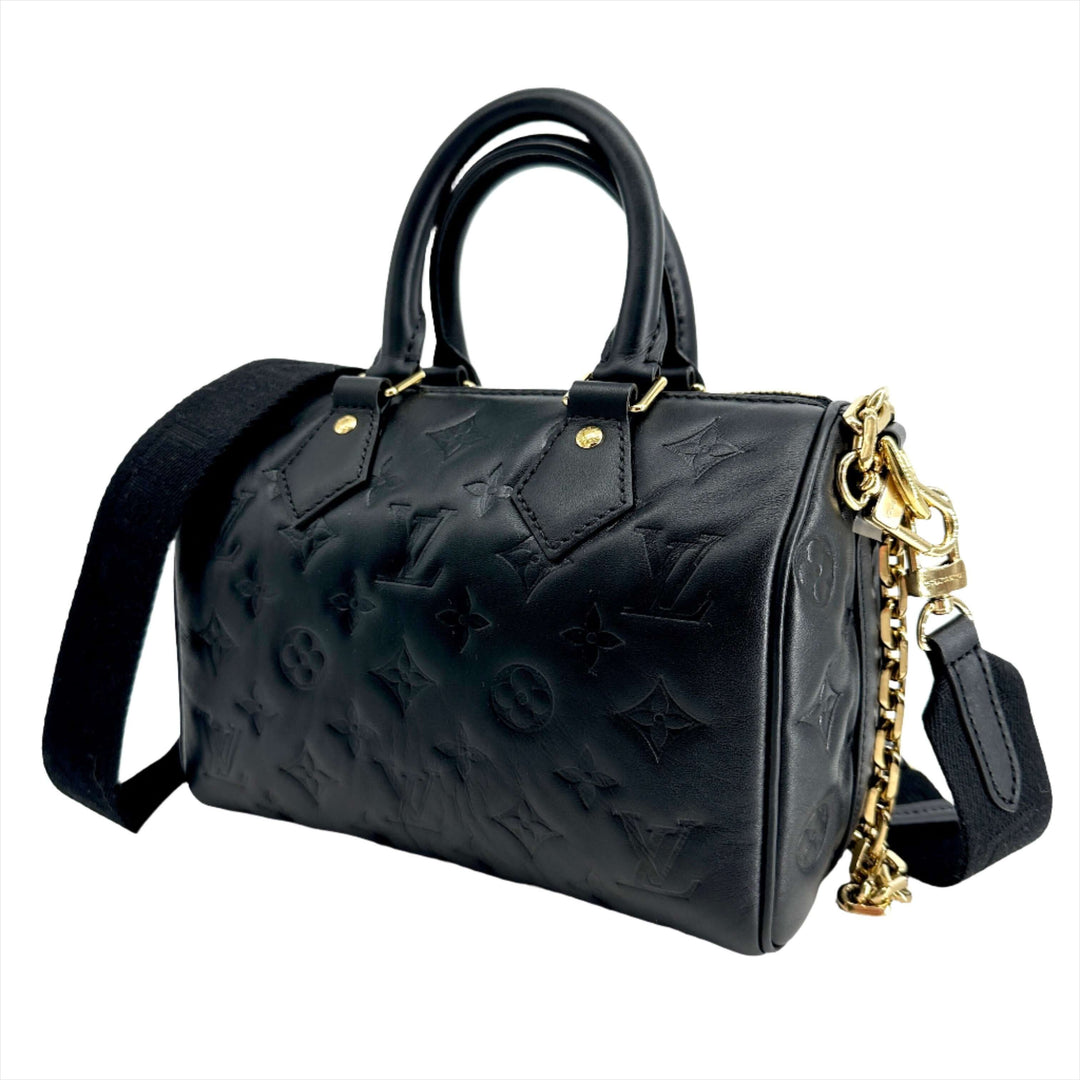 LOUIS VUITTON Lambskin Embossed Monogram Speedy 22 Bandouliere Black handbag with gold hardware and black strap.