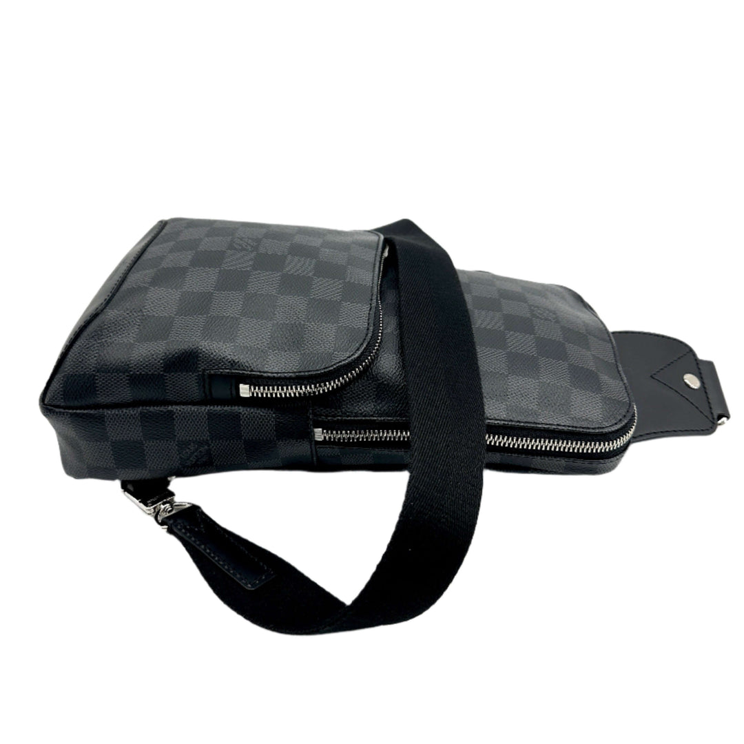 Side view of Authentic LOUIS VUITTON Damier Graphite Avenue Sling Backpack showing black checkered canvas and adjustable strap