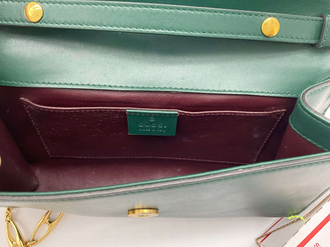 Interior view of Gucci Zumi Smooth Leather Small Shoulder Bag showcasing the spacious compartment and luxurious green and burgundy lining.