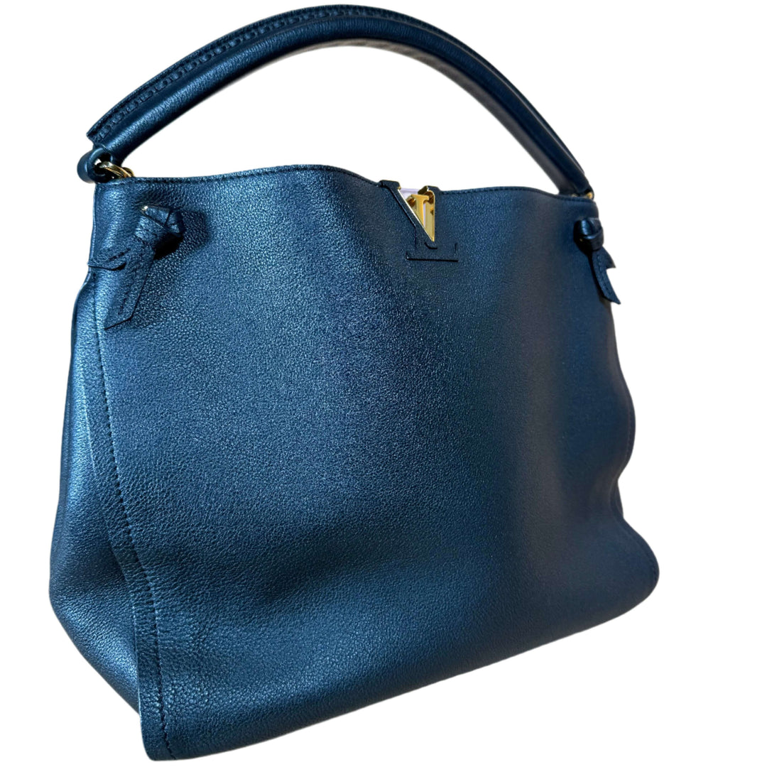 Elegant navy handbag with a smooth texture and structured design, featuring a sturdy handle and gold hardware.