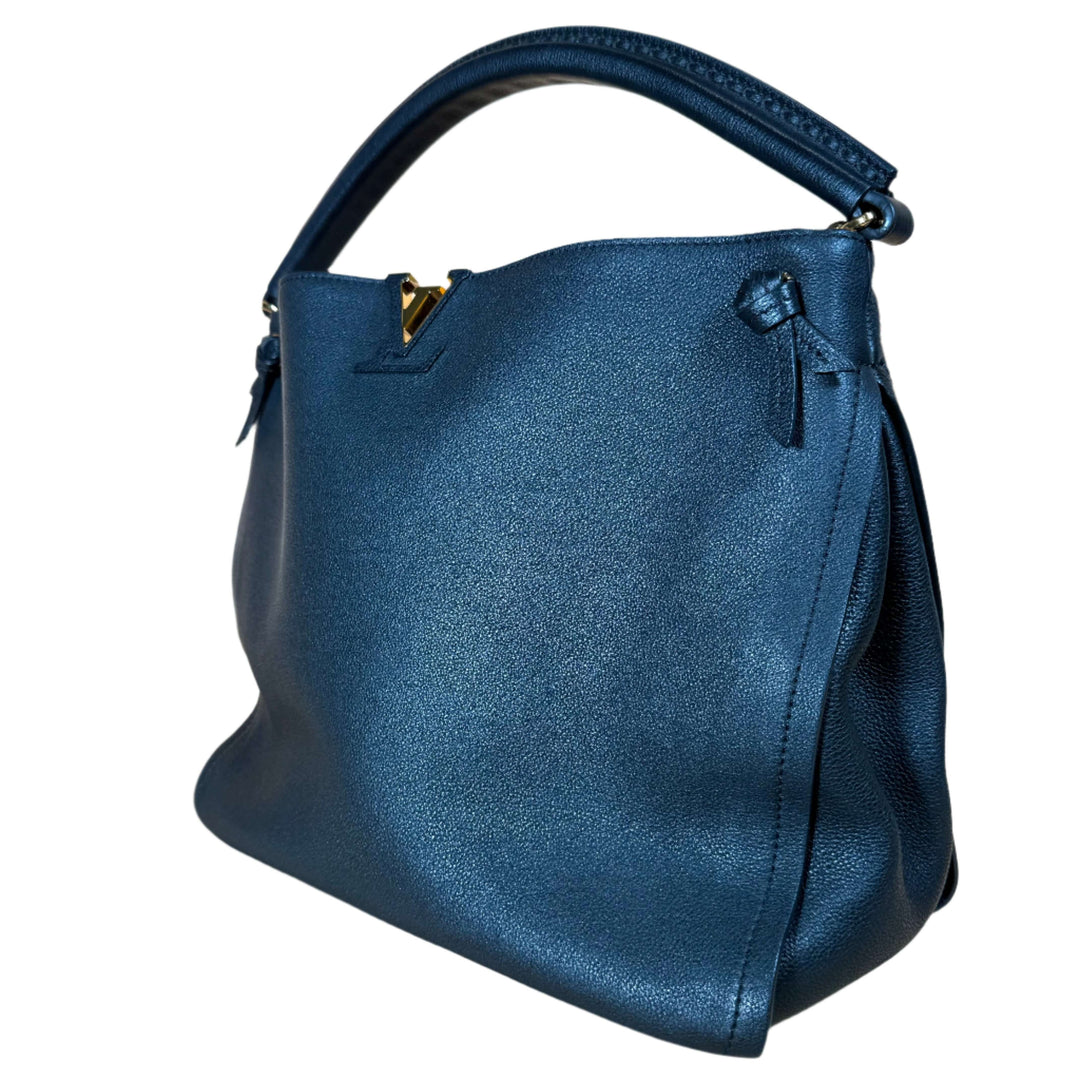 Elegant blue handbag with smooth leather finish and stylish handle, perfect for any sophisticated outfit.