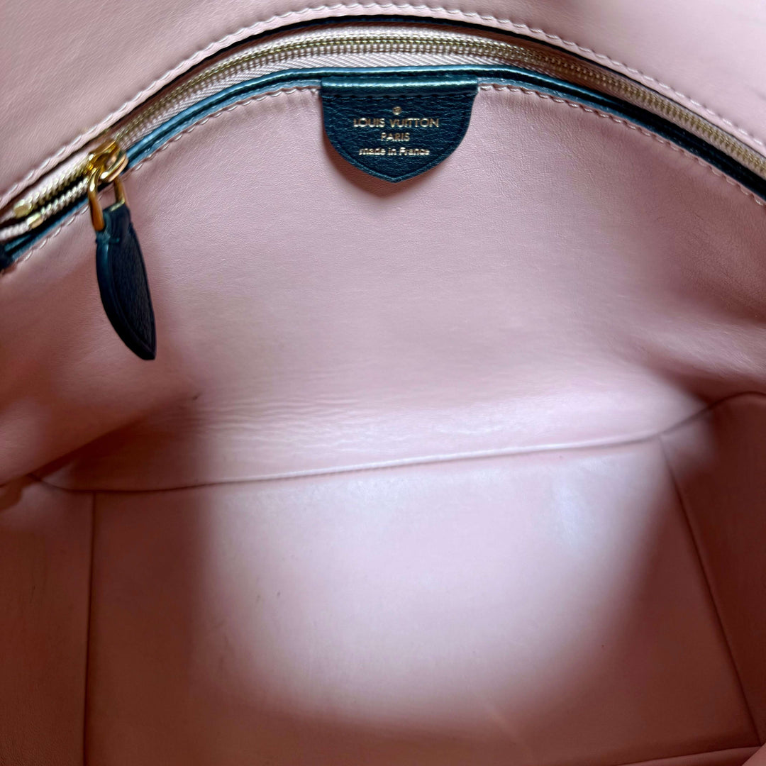 Interior view of Louis Vuitton bag featuring a zip pocket and brand label, showcasing its elegant craftsmanship.