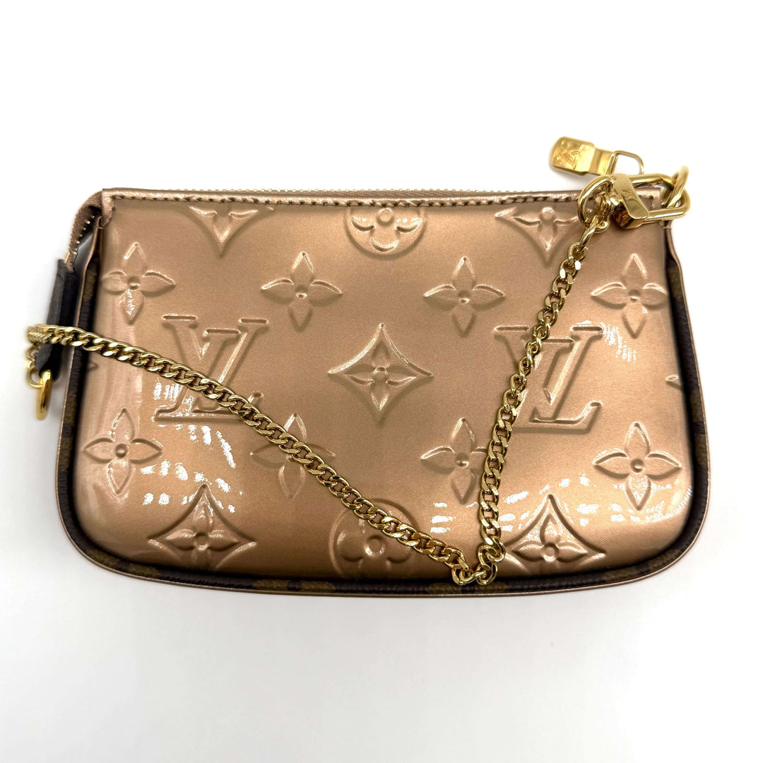 Authentic Louis Vuitton Metallic Vernis Mini Pochette in Rose Gold with gold-tone hardware and wristlet chain.