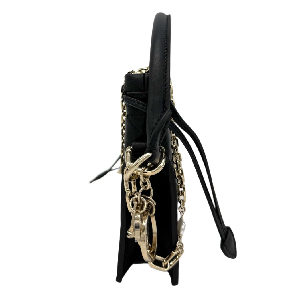 Side view of Christian Dior Lambskin Cannage Mini Top Handle Drawstring Bag in Black with silver accents and chain detail.