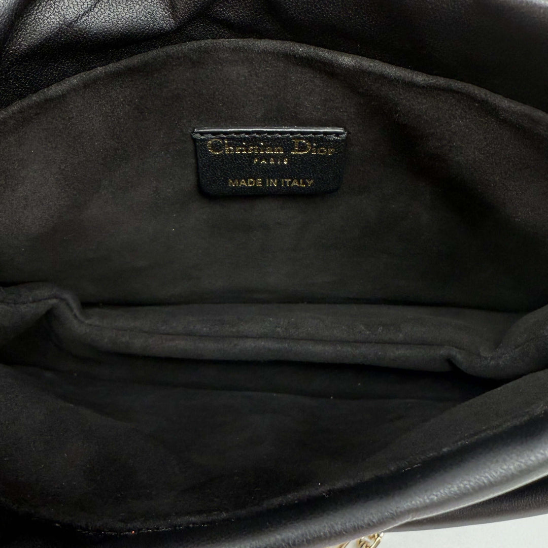 Interior view of the Authentic Christian Dior Lambskin Cannage Mini Top Handle Drawstring Bag, showcasing its luxurious black lining and label.