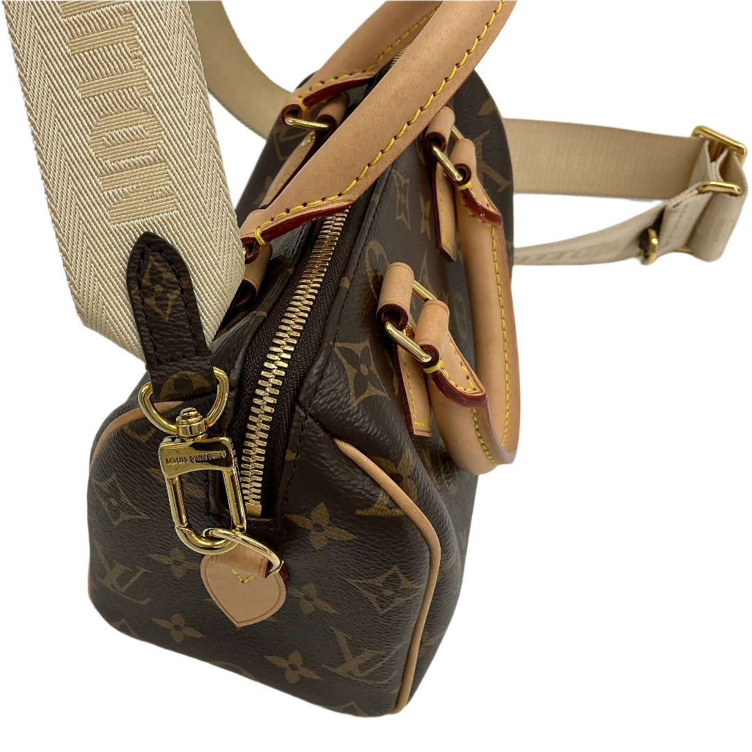 Close-up of Louis Vuitton bag with beige jacquard strap and monogram print in brown and tan leather.