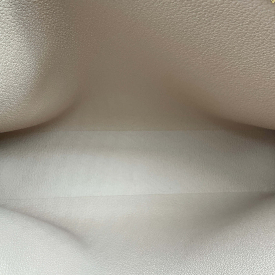 Interior view of Louis Vuitton Monogram Toiletry Pouch 26, featuring a spacious and elegant light-colored lining.