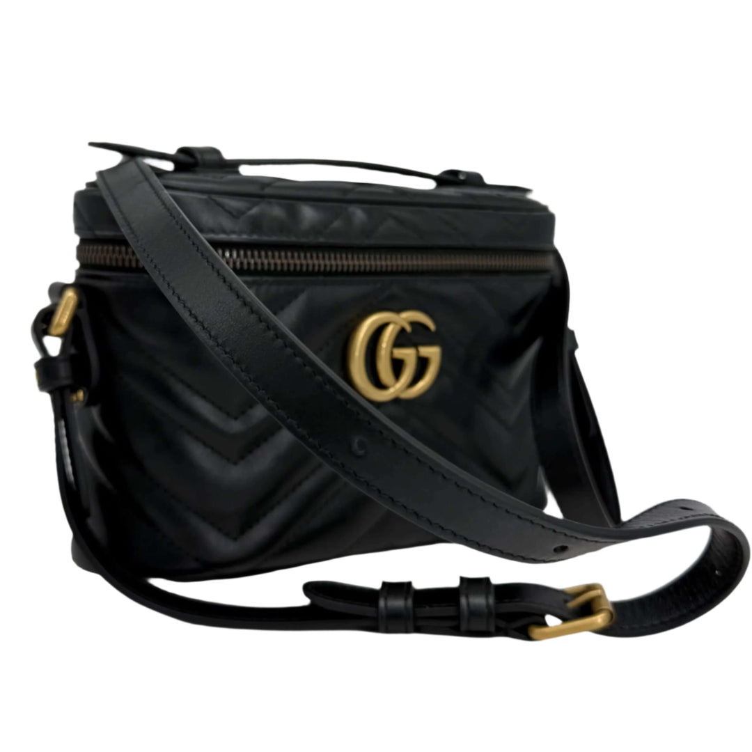 Gucci black calfskin Matelassé mini bag with GG logo and adjustable strap, featuring chevron quilted design.