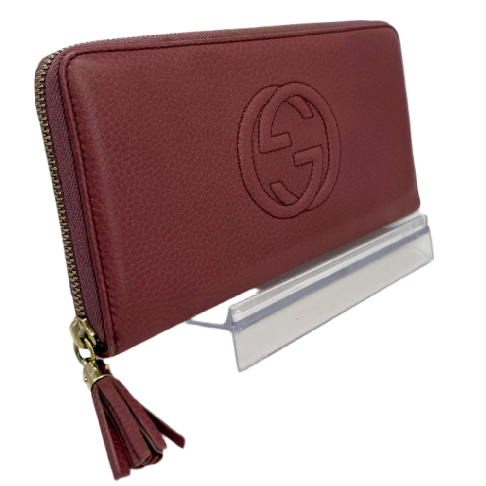 Gucci Zippy Leather Wallet in mauve pink with logo and zipper detailing, elegant pre-owned accessory.