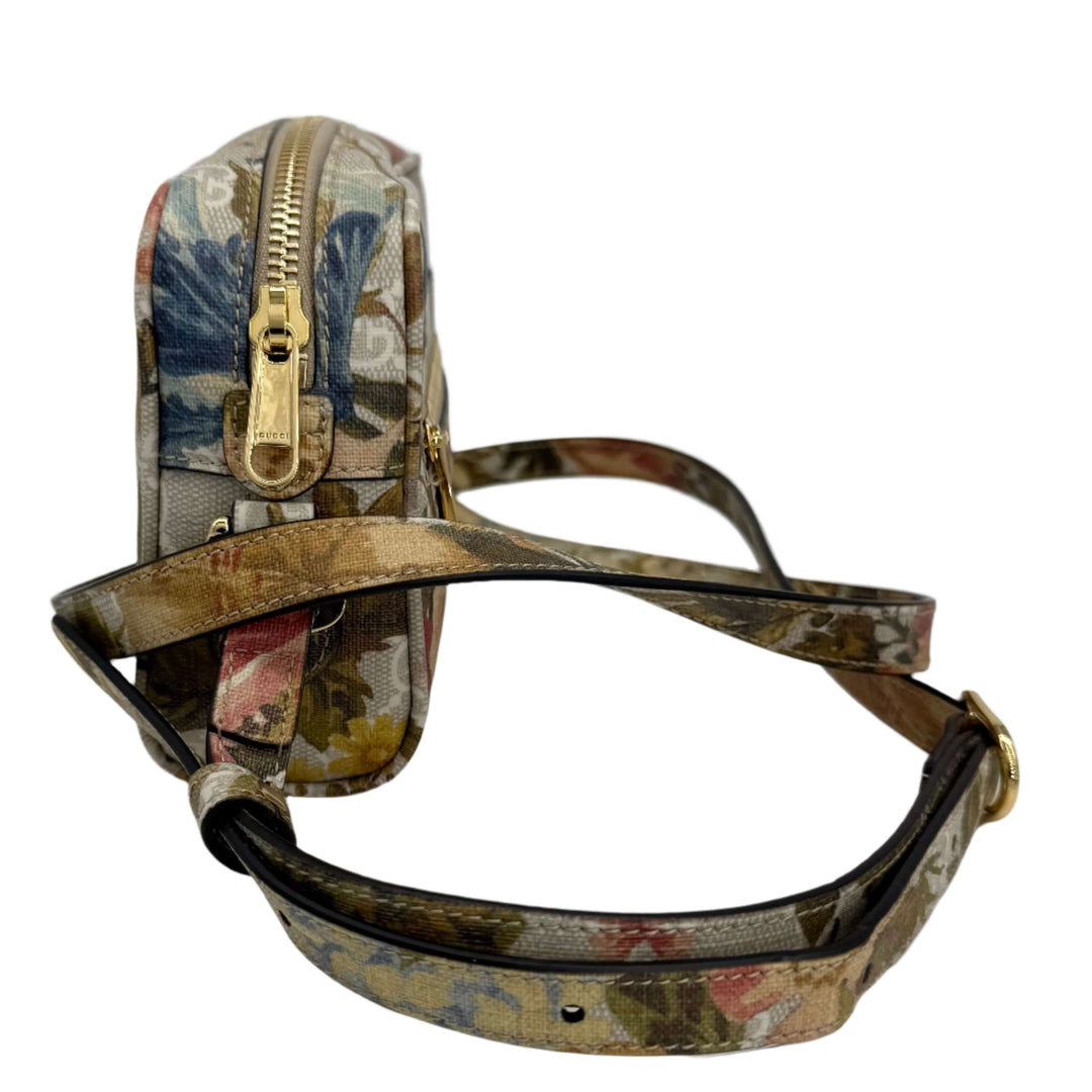 Side view of a floral print handbag with gold zipper and adjustable strap, showcasing elegant design details.