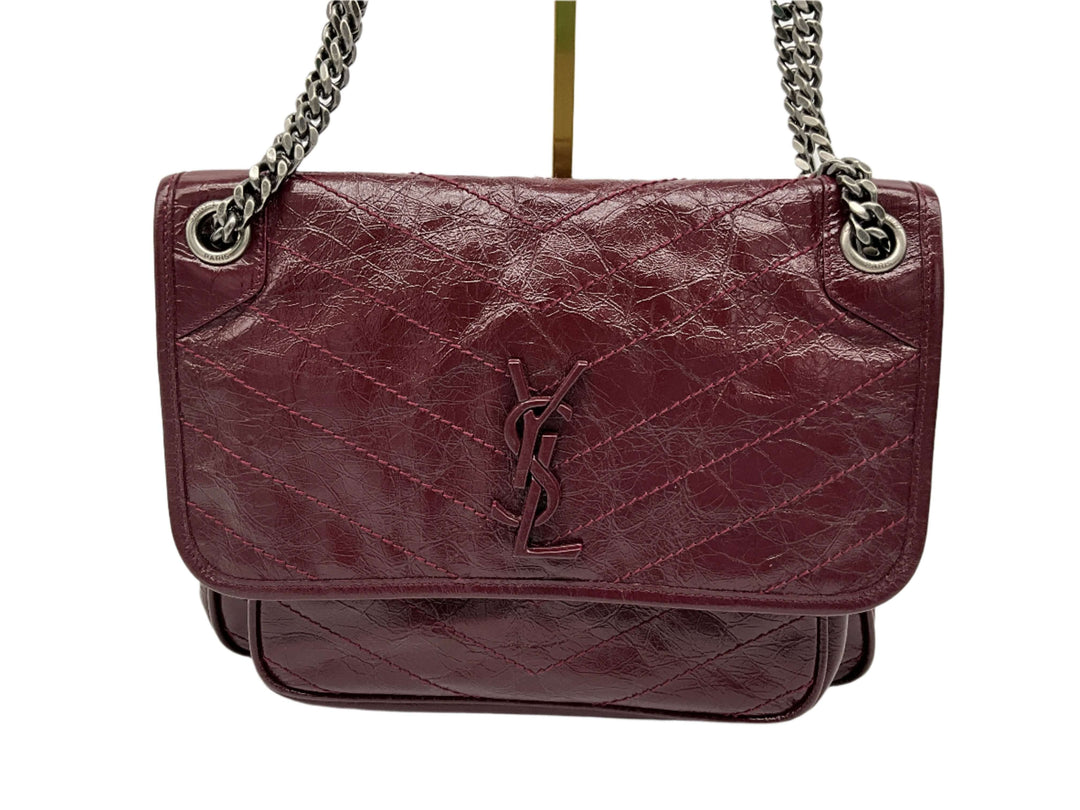 SAINT LAURENT Rouge Legion crinkled calfskin Niki chain satchel with monogram logo and quilted design.