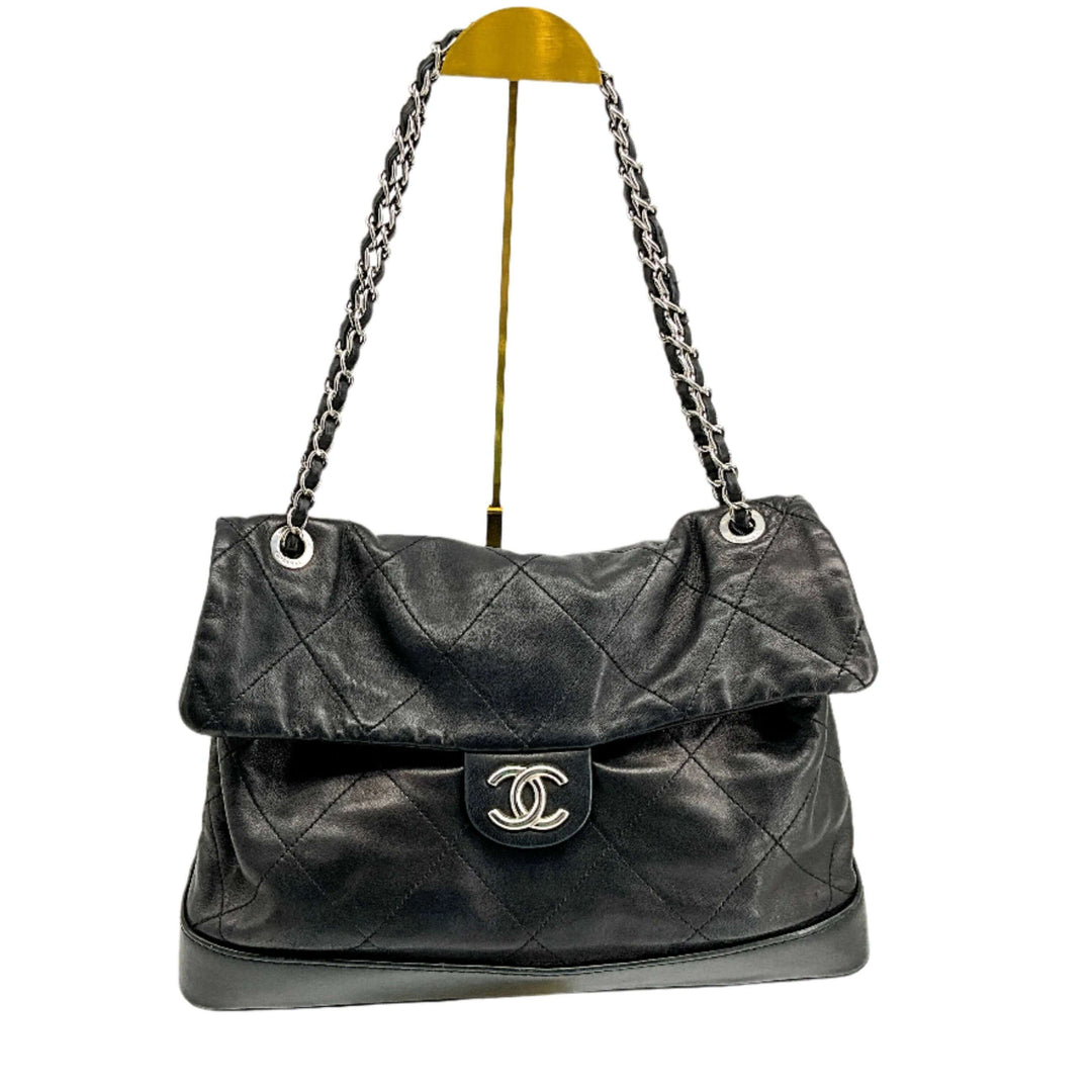 Black CHANEL Calfskin Quilted VIP Flap Bag with Iconic CC Logo and Chain Straps on Display