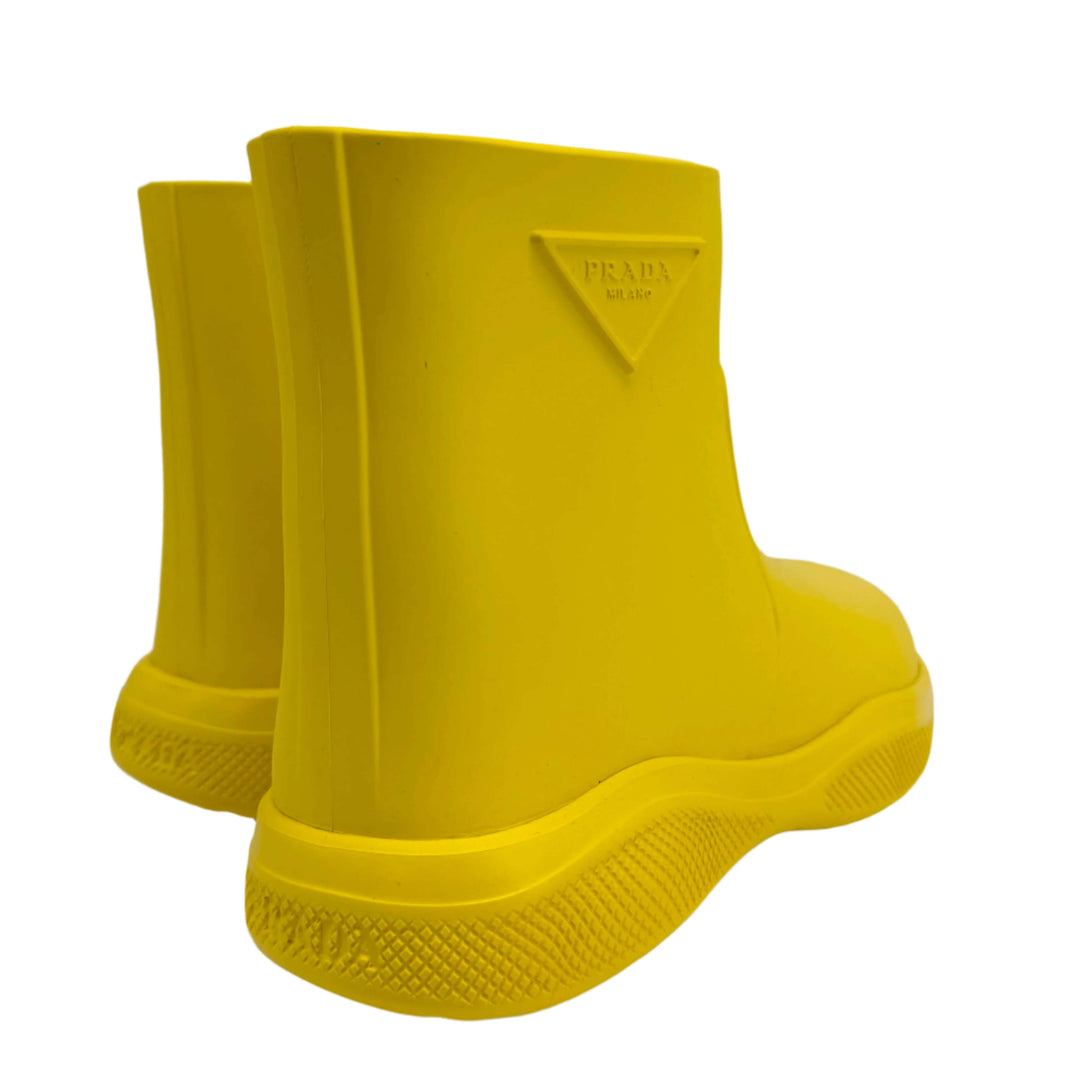 Authentic pre-owned Prada yellow rubber rain boots, size 35, showcasing vibrant design and slip-resistant soles.