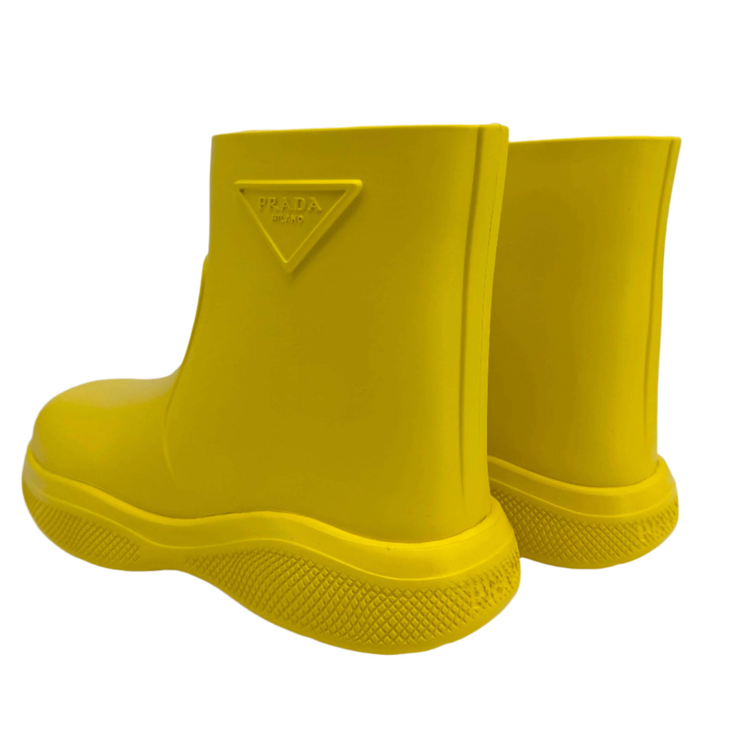 Authentic pre-owned Prada yellow rubber rain boots in size 35 with slip-resistant soles and iconic branding.