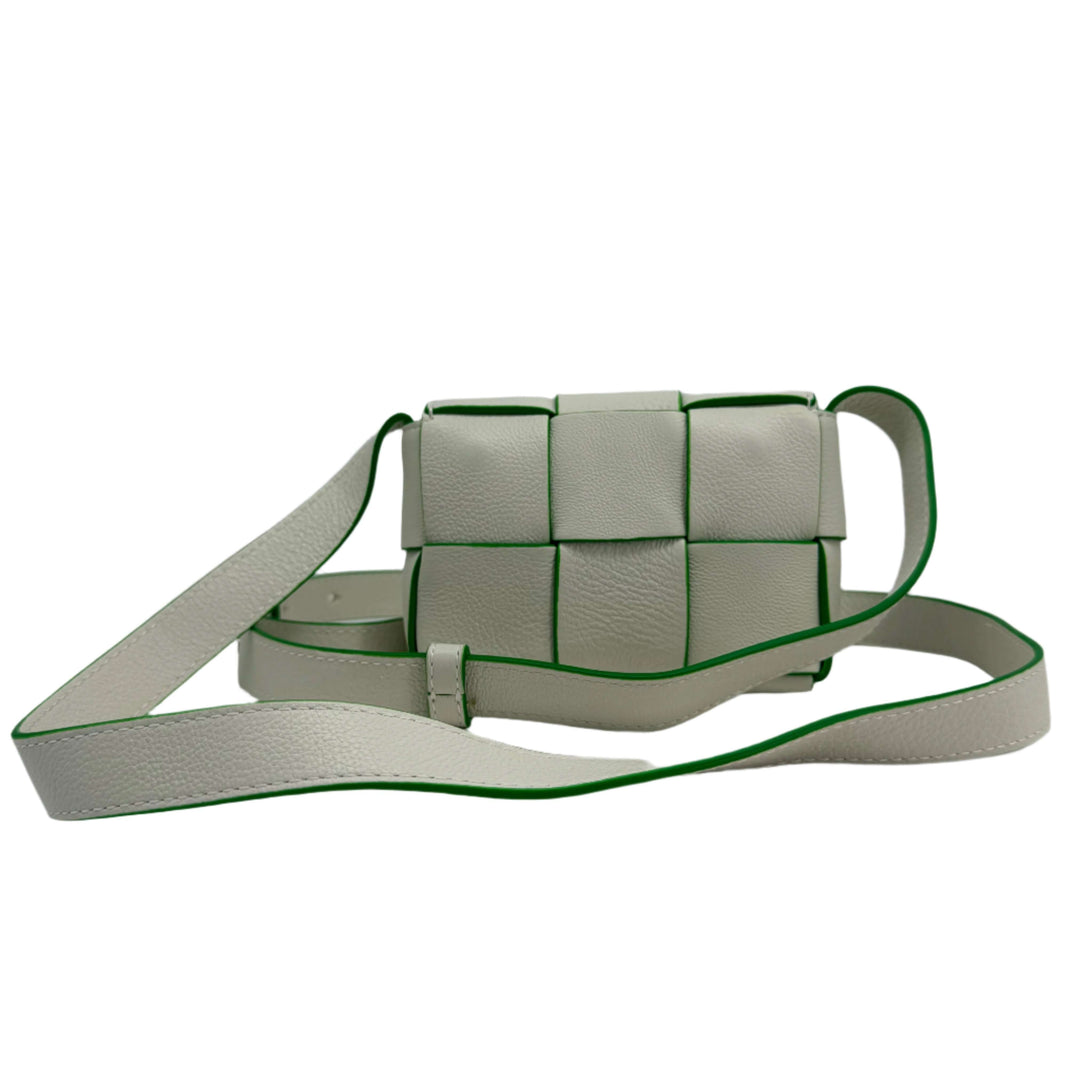 Bottega Veneta Buffalo Maxi Intrecciato Extra Mini Cassette Crossbody bag in white with green trim.