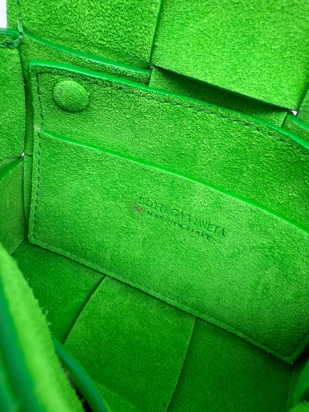 Interior view of Bottega Veneta Buffalo Maxi Intrecciato Extra Mini Cassette in vibrant green suede.