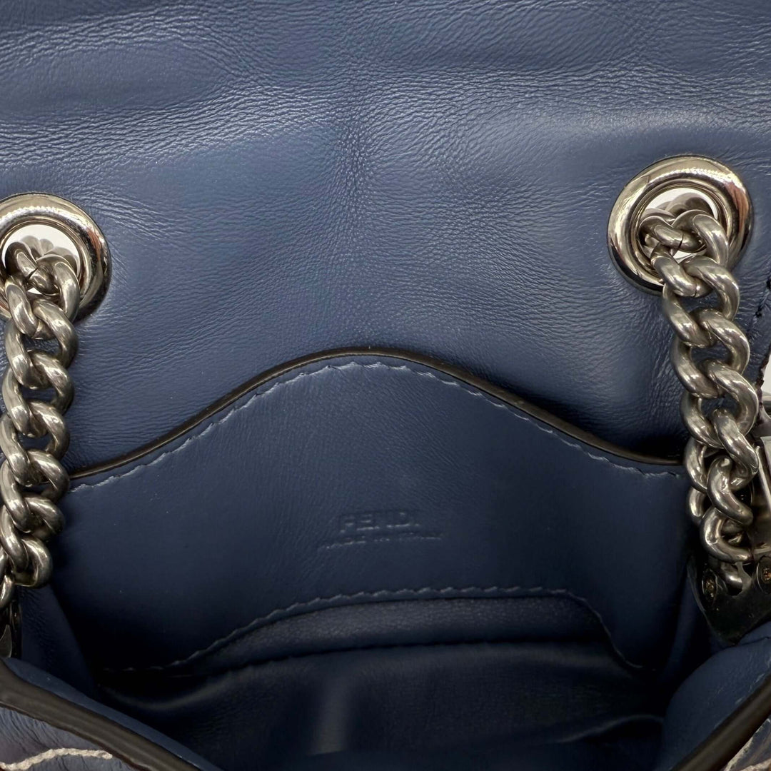 Interior view of Fendi Blue Embossed Stitched Leather Nano Baguette Crossbody Bag showcasing chain details.