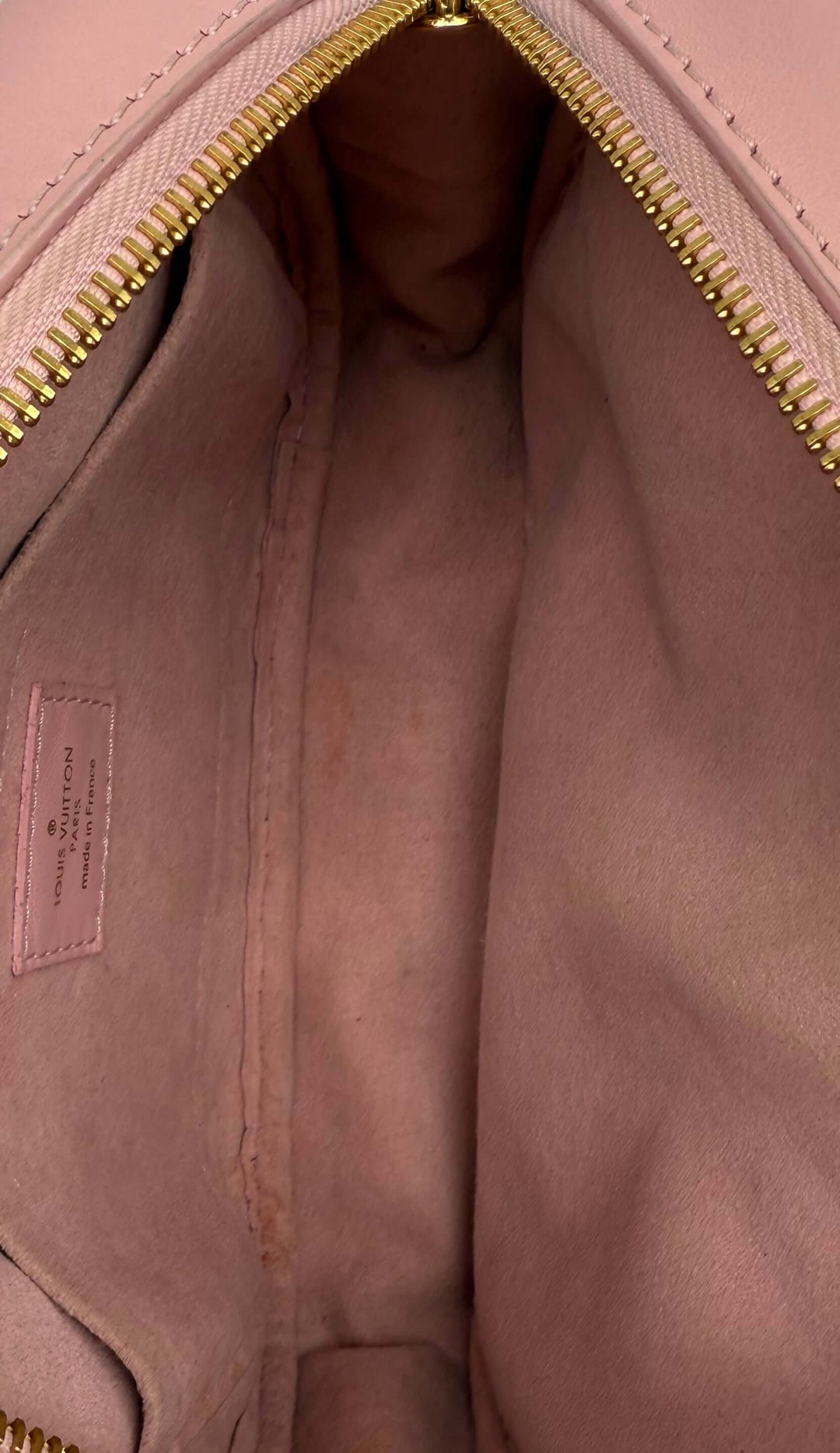 Interior view of a Louis Vuitton Quilted Calfskin New Wave Camera Bag in Smoothie Pink with gold-tone zipper.