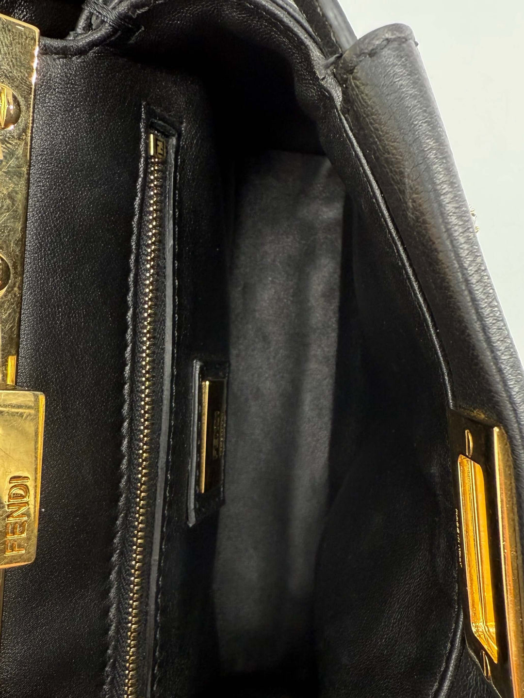 Interior view of the Fendi Nappa Crystal Studded XS Peekaboo Satchel showing black leather lining and gold hardware.