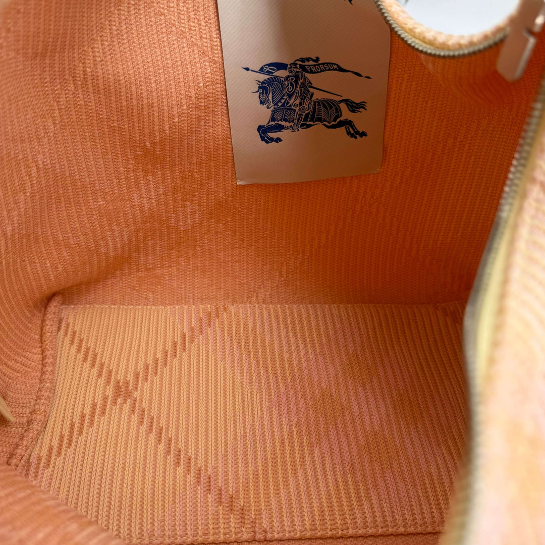 Interior view of the Burberry Canvas Peg Medium Duffle Bag showing orange textile lining and logo label.