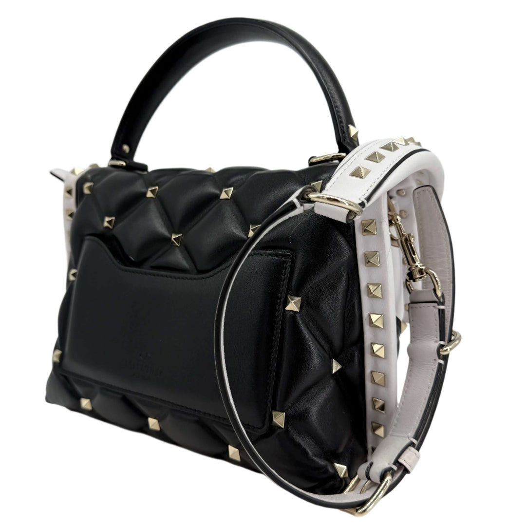 Valentino Garavani Nappa Medium Candystud Top Handle Bag in white and black, featuring diamond-quilted design and studded accents.