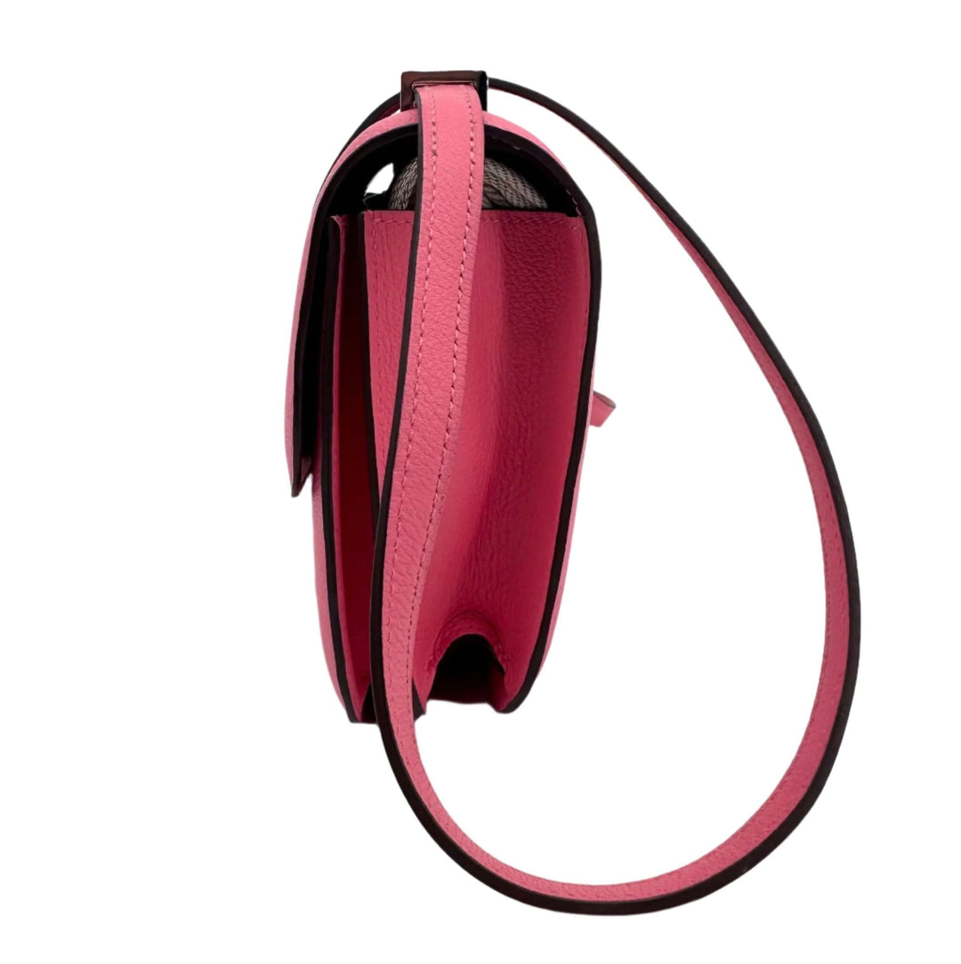 Side view of a pink HERMES Epsom Constance 24 shoulder bag with a sleek strap design.