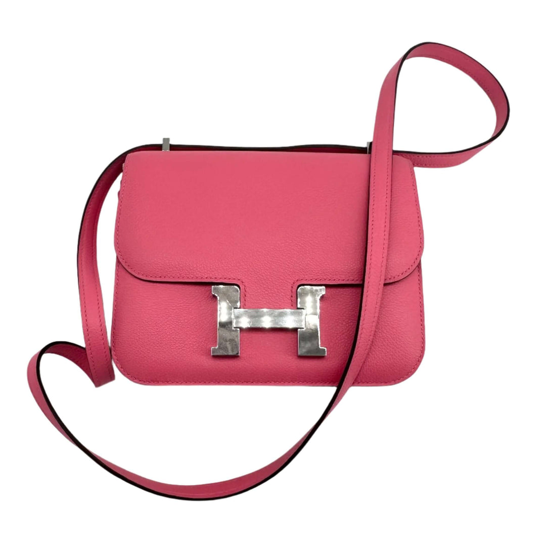 Pink HERMES Epsom Constance 24 Shoulder Bag with signature silver H clasp and adjustable strap on white background.