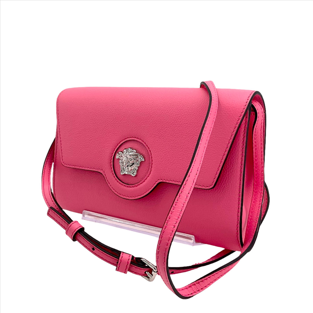 VERSACE Medusa Crossbody Bag in pink leather with adjustable strap and signature Medusa logo. Stylish and elegant designer handbag.