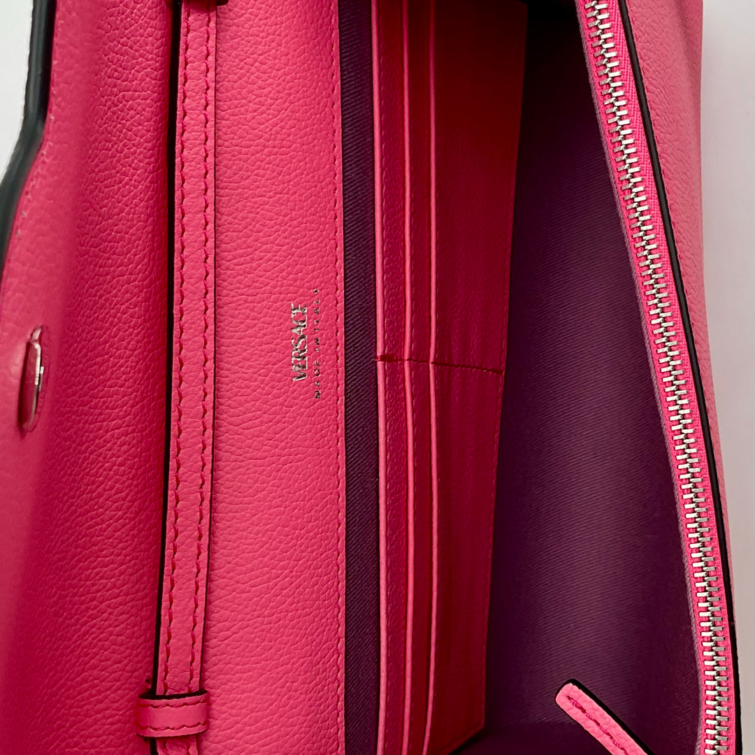 Close-up of the VERSACE Medusa Crossbody Bag in pink, showcasing the interior compartments and zip details.